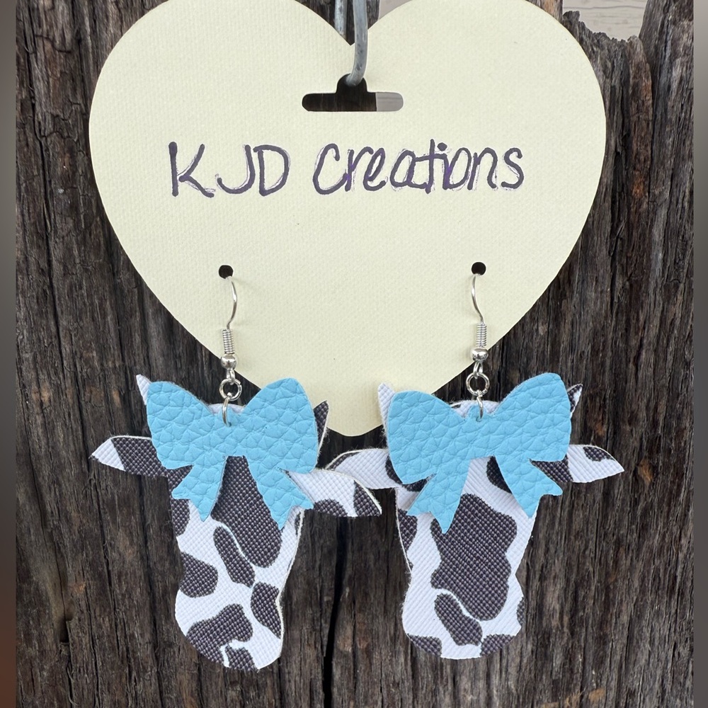 Faux leather dangle Black & white Cow Print Earrings with blue bow accent